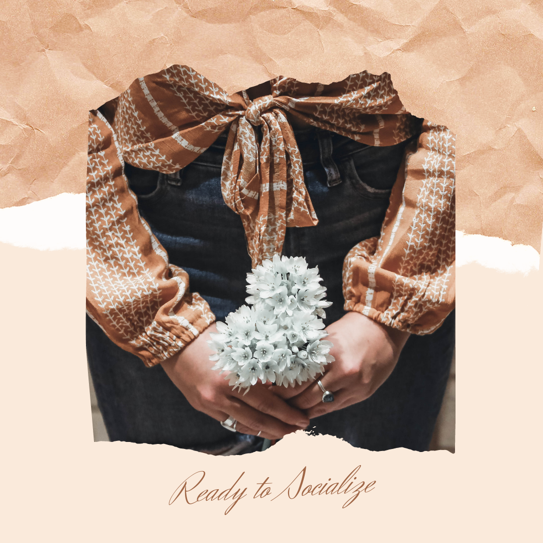 Hands in dark jeans hold white flowers beneath a brown patterned blouse on a torn-paper background; text says Ready to Socialize.